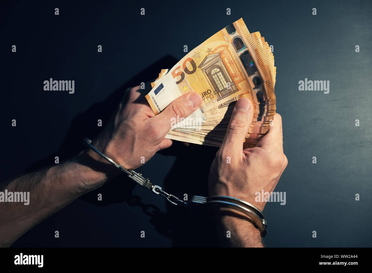 financial crime concept - cuffed hands with cash money Stock Photo
