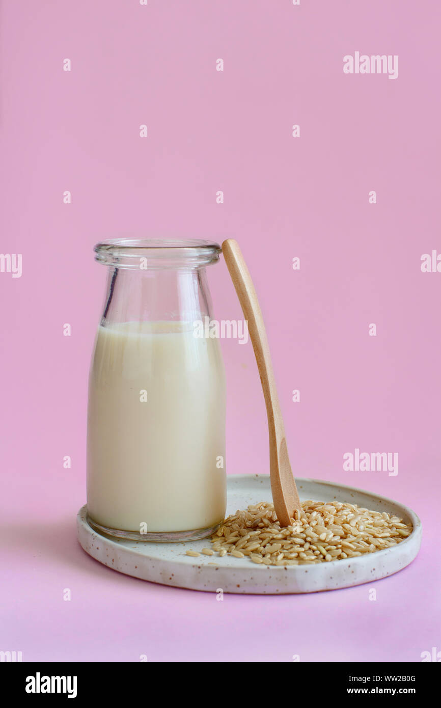 Vegan rice milk, non dairy alternative milk in a bottle on a pink