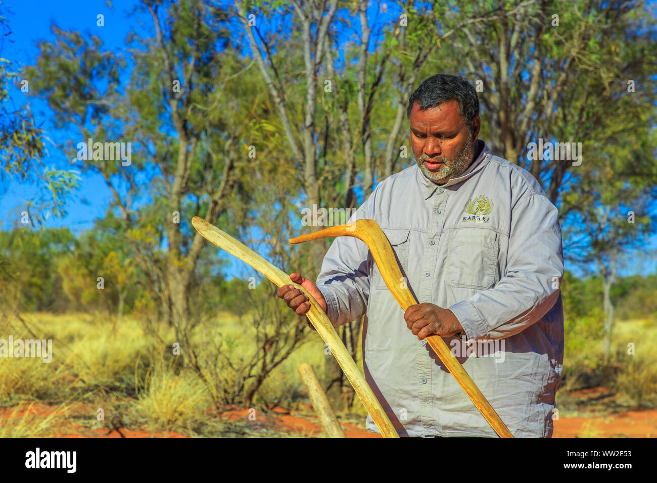 Kings Creek Station, Northern Territory, Australia - Aug 21, 2019: aboriginal Australian man holding an aboriginal weapon of boomerang used by Luritja Stock Photo
