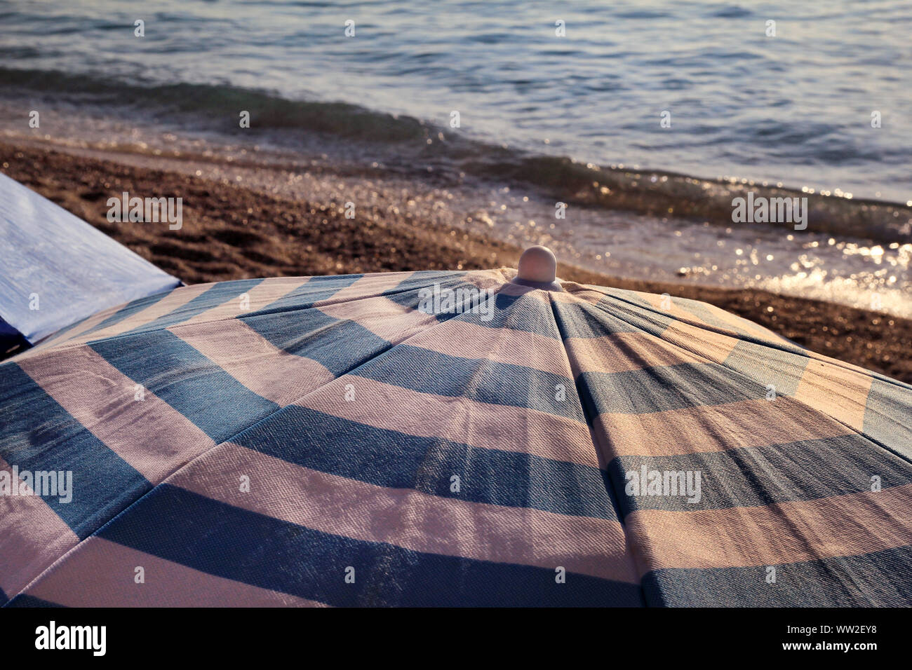 Red, blue and white sun umbrella for sunbathing and protection of sun