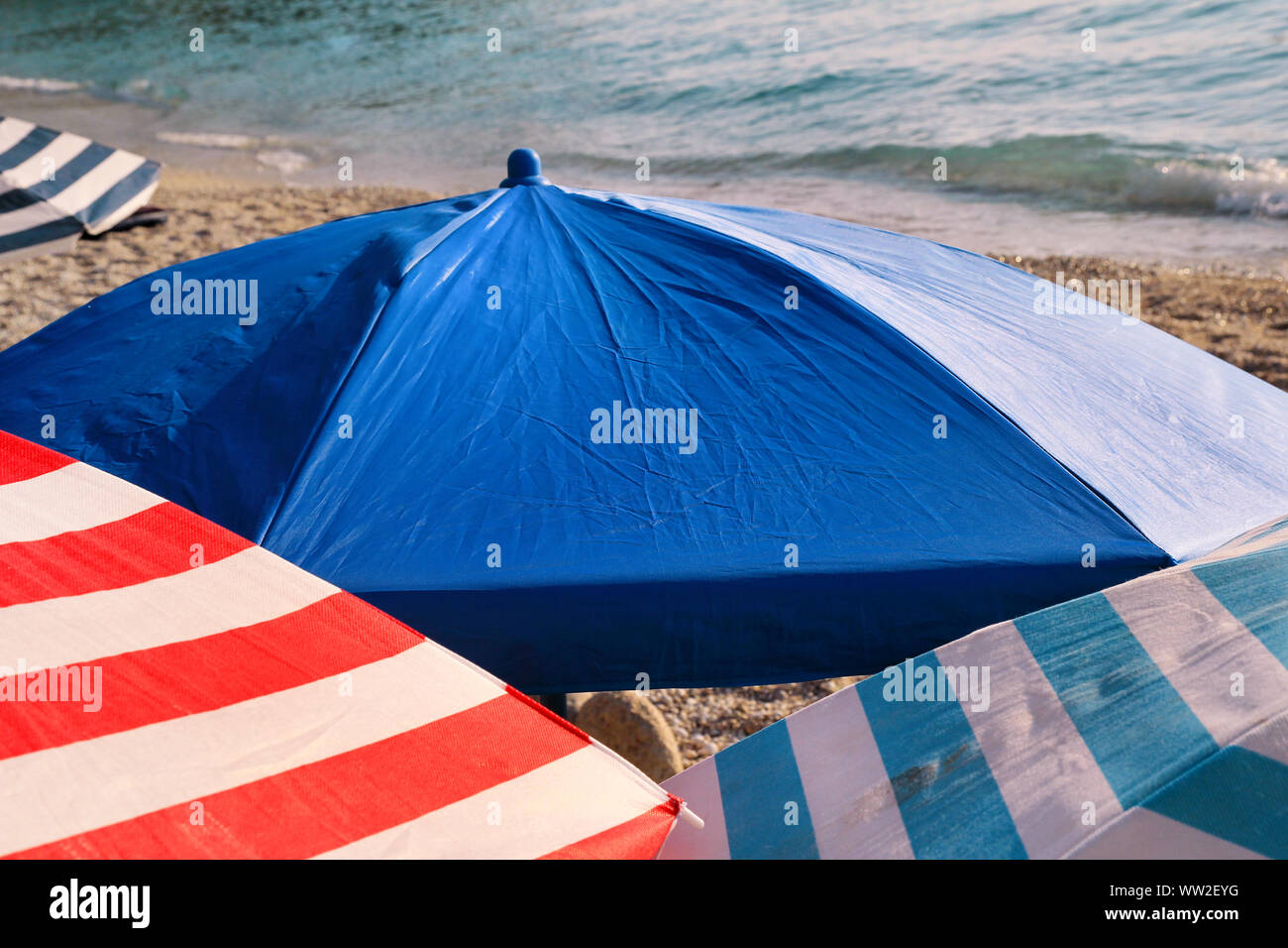 Red, blue and white sun umbrella for sunbathing and protection of sun