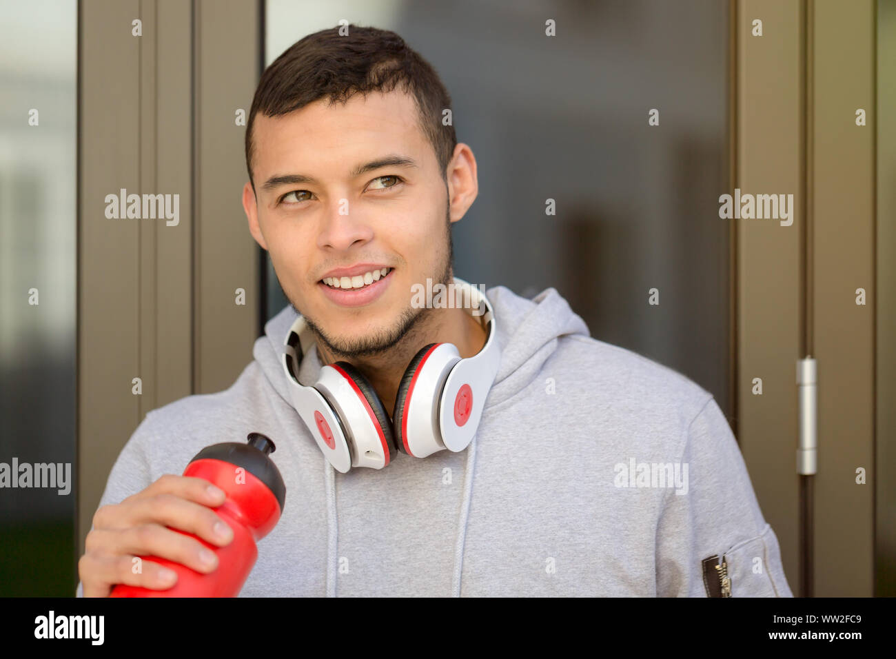 Sports training young latin man drinking water runner looking up copyspace copy space outdoor Stock Photo