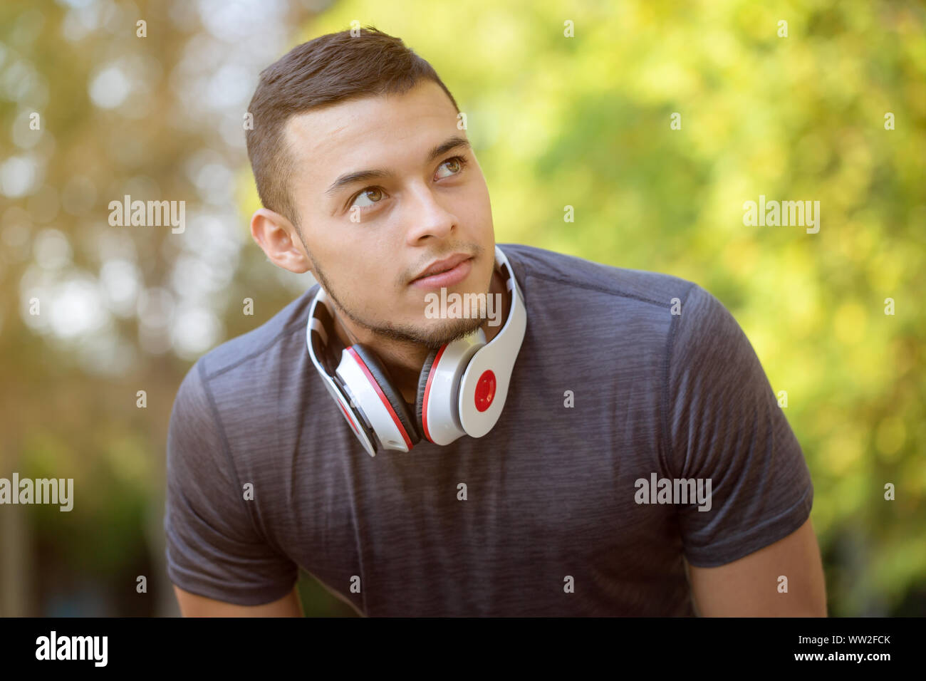 Young latin man runner looking up thinking sports training fitness workout copyspace copy space outdoor Stock Photo