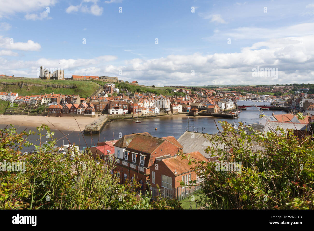 Whitby, North Yorkshire, UK: Looking east from the West Cliff over the River Esk and harbour. St Mary and the abbey ruins are on the opposite cliff. Stock Photo