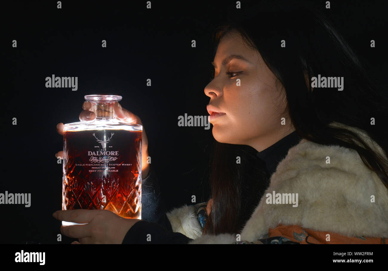 JON SAVAGE PHOTOGRAPHY BONHAMS ASIAN ART AND WHISKY SALE;   ERAENA VALERY ONE OF THE BONHAMS AUCTIONEER TEAM PICTURED WITH A DALMORE FIFTY YEAR OLD  1926 BOTTLE OF WHISKY WHICH HAS AN ESTIMATE VALUE OF £15-000-£20,000. Stock Photo