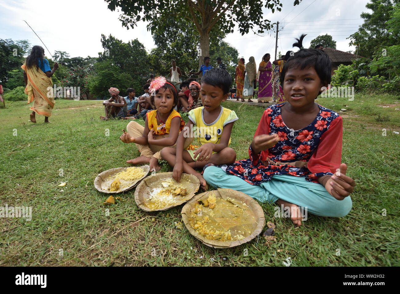 Three girls are taking the open air lunch on the ground. Jhargram, West Midnapore, India. Stock Photo