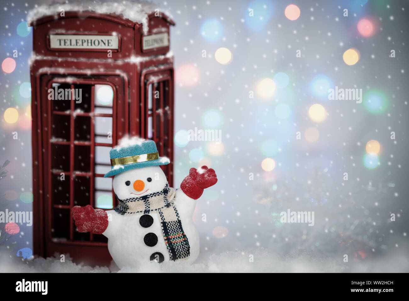 A snowman playing snow near phone box on snowfall with copy space for ...