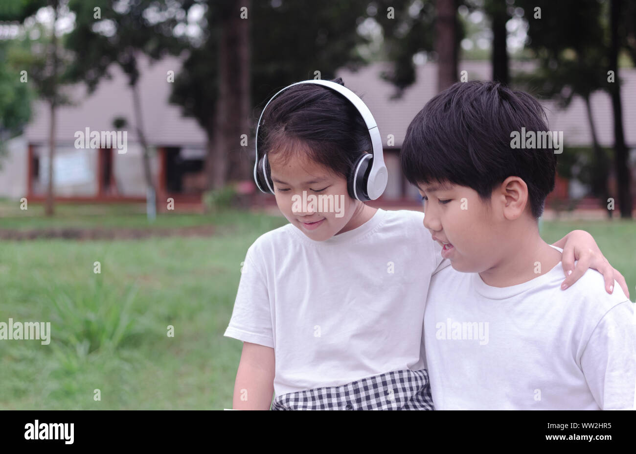 Brother and sister relaxing in the park Stock Photo - Alamy