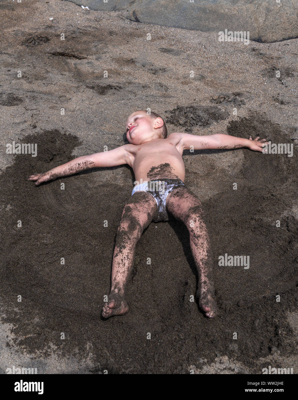 Young boy playing in the sand at the beach, Akranes, Iceland Stock Photo