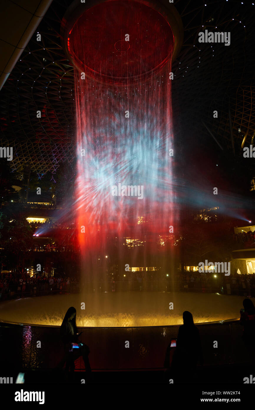 SINGAPORE - CIRCA APRIL, 2019: 40-meter HSBC Rain Vortex, the world’s tallest indoor waterfall at the Jewel Changi Airport at night. Stock Photo