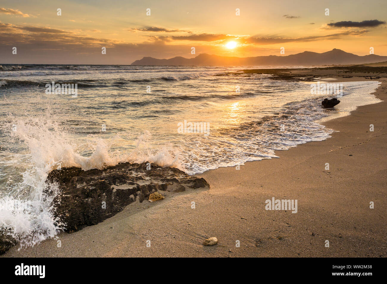Water splashing on a rock during sunrise, beach of Mallorca Stock Photo
