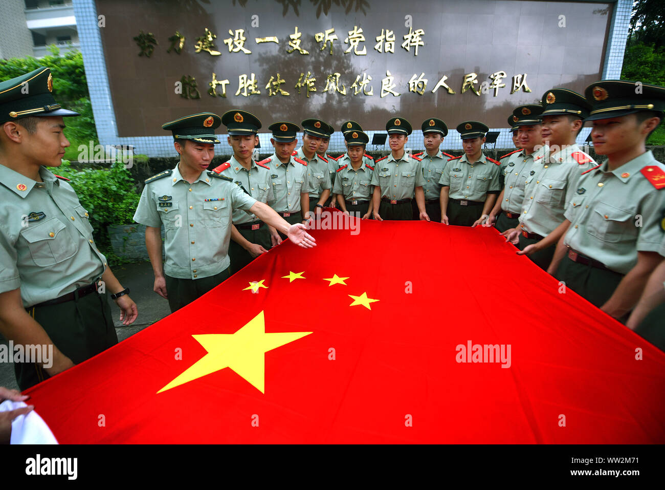 Chinese paramilitary policemen of the local armed police force holds a Chinese national flag during a swearing-in ceremony as members of the Chinese C Stock Photo