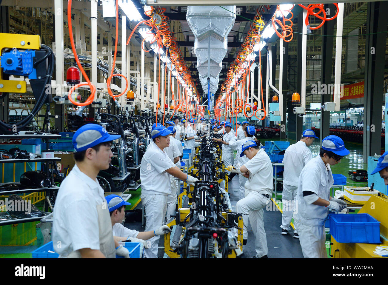 Chinese factory workers assemble motorcycles on the assembly line at the plant of Sundiro Honda Motorcycle Co., Ltd. in Taicang City, east China's Jia Stock Photo