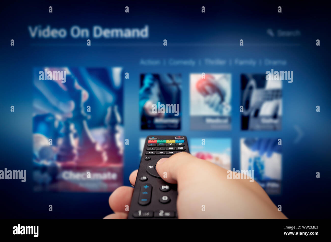 VOD service screen with remote control in hand