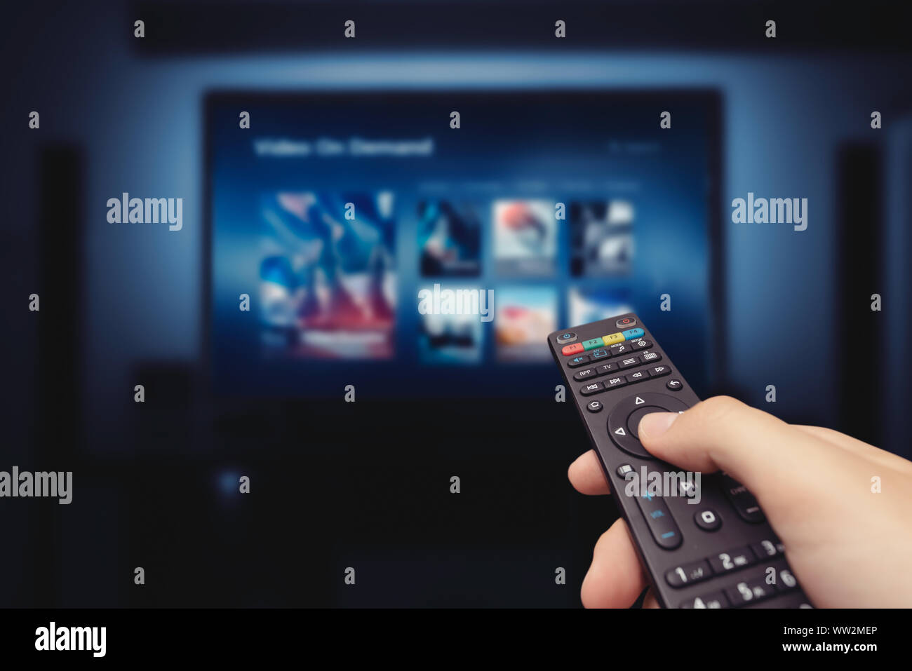 VOD service screen with remote control in hand. Video On Demand television internet stream multimedia concept Stock Photo