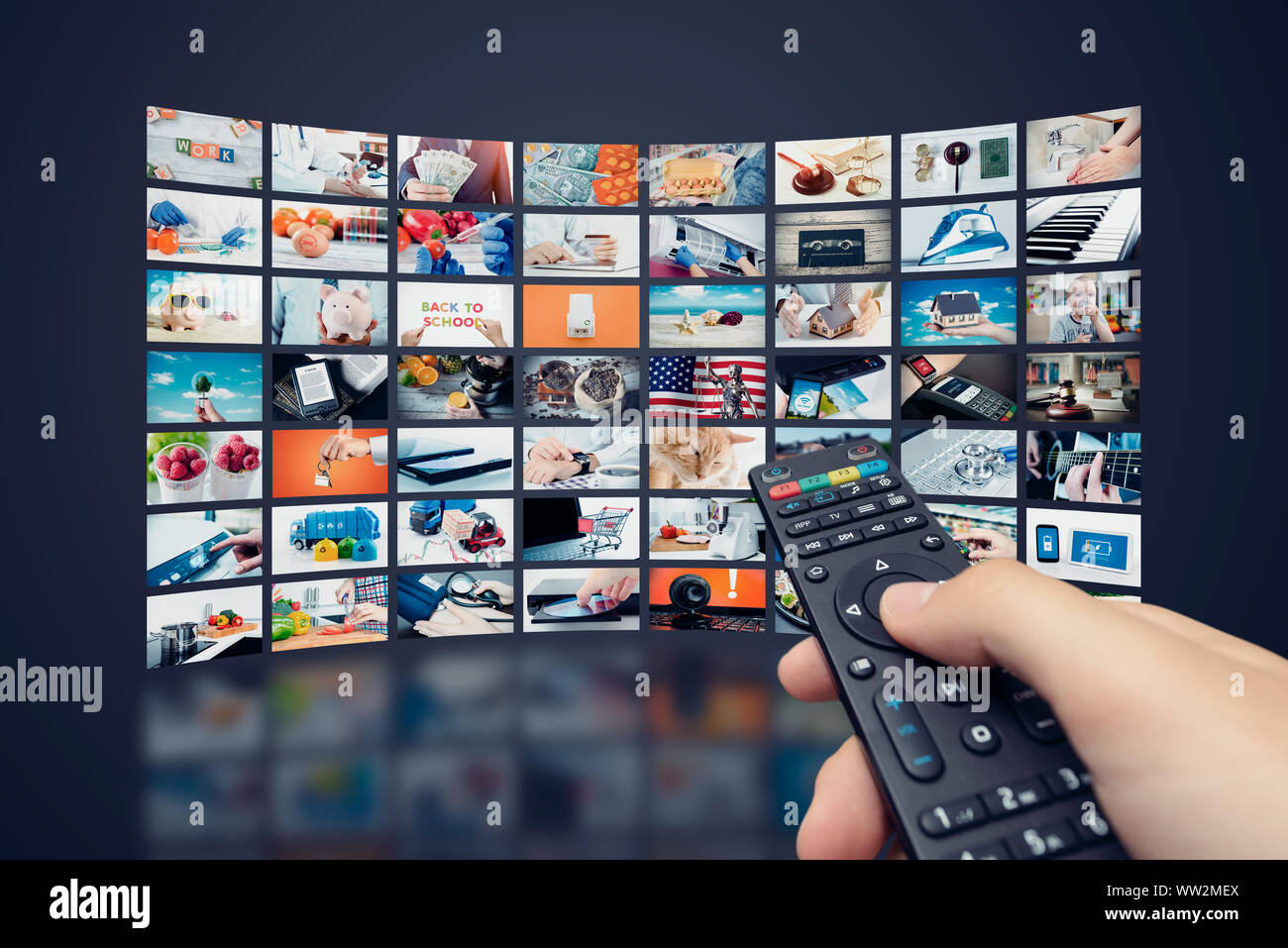 Multimedia video wall television broadcast. Hand holding remote control. Stock Photo