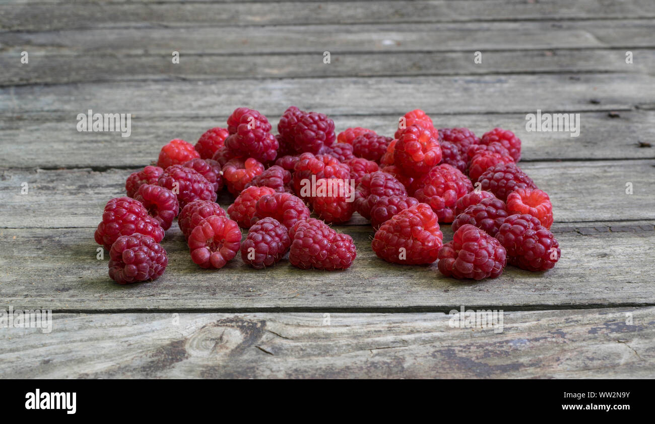 Fresh raspberries on old , rustic, wooden table. Stock Photo