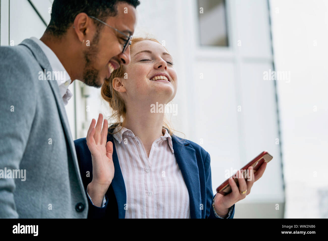 Couple using smart phone outdoors Stock Photo