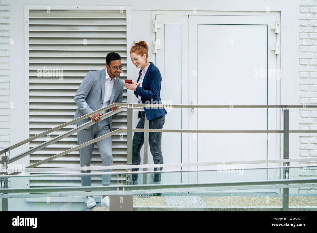Couple using smart phone outdoors Stock Photo