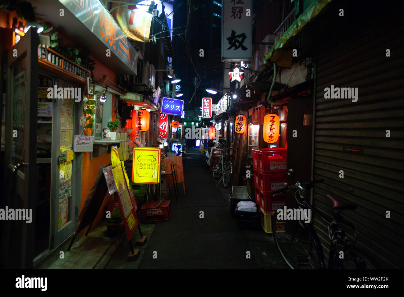 Illuminated signs of shops and bar at night Stock Photo