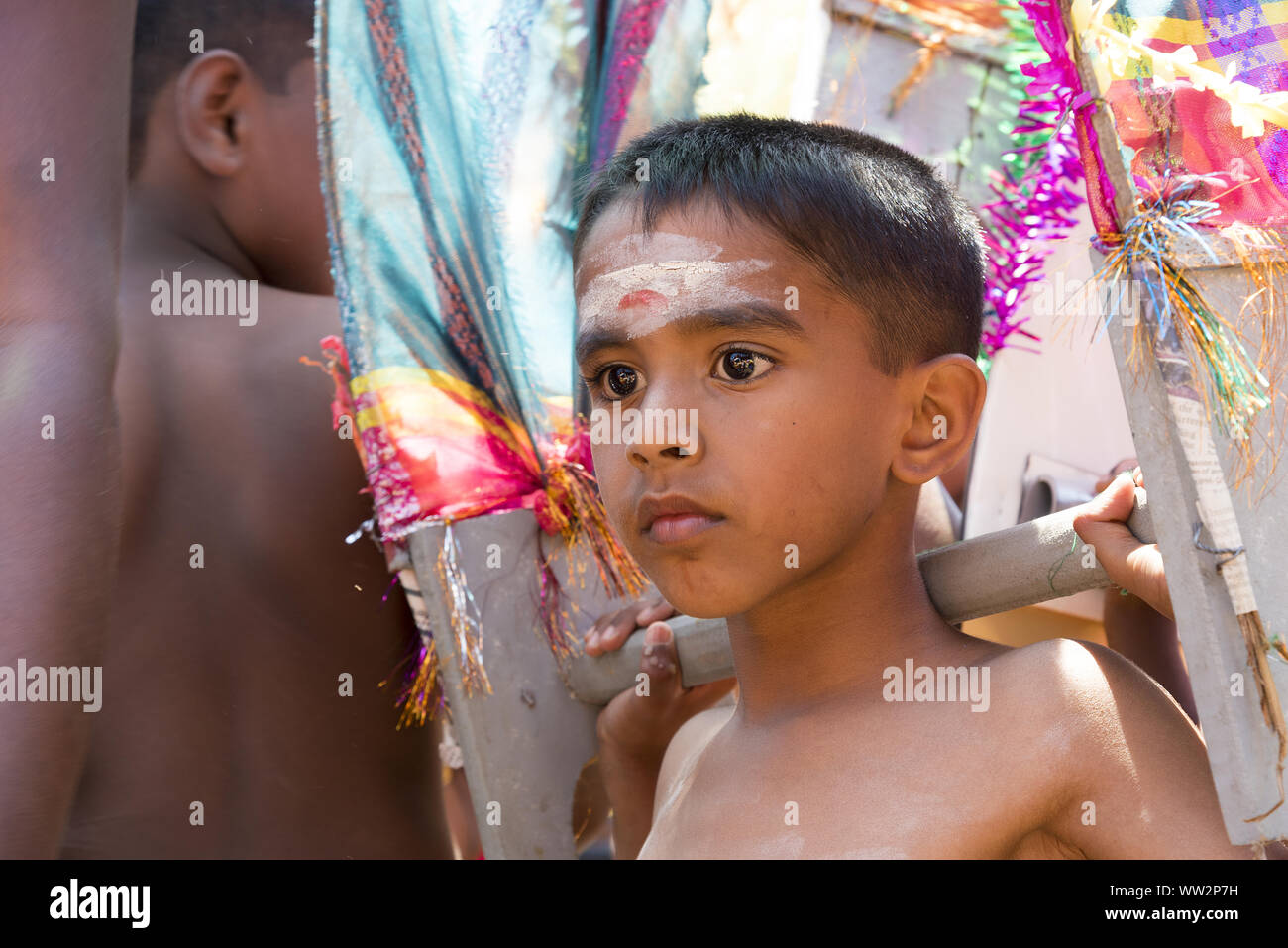 Pussellawa, Sri Lanka,  03/20/2019: Hindu festival of Thaipusam - body piercing rituals under the blood moon. Boy carrying symbolic weight. Stock Photo