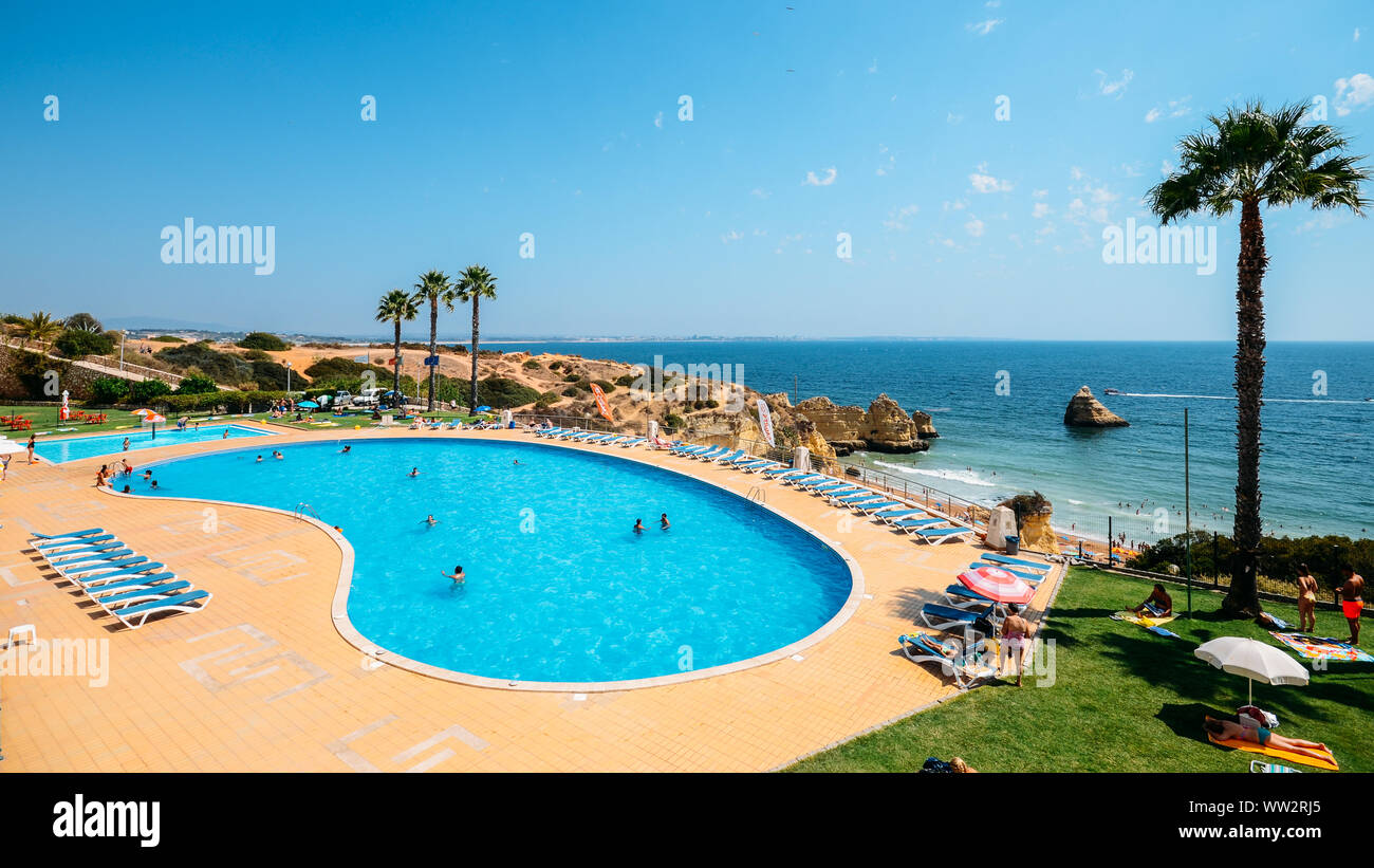 Algarve, Portugal - Sept 6, 2019: Busy swimming pool overlooking Cova