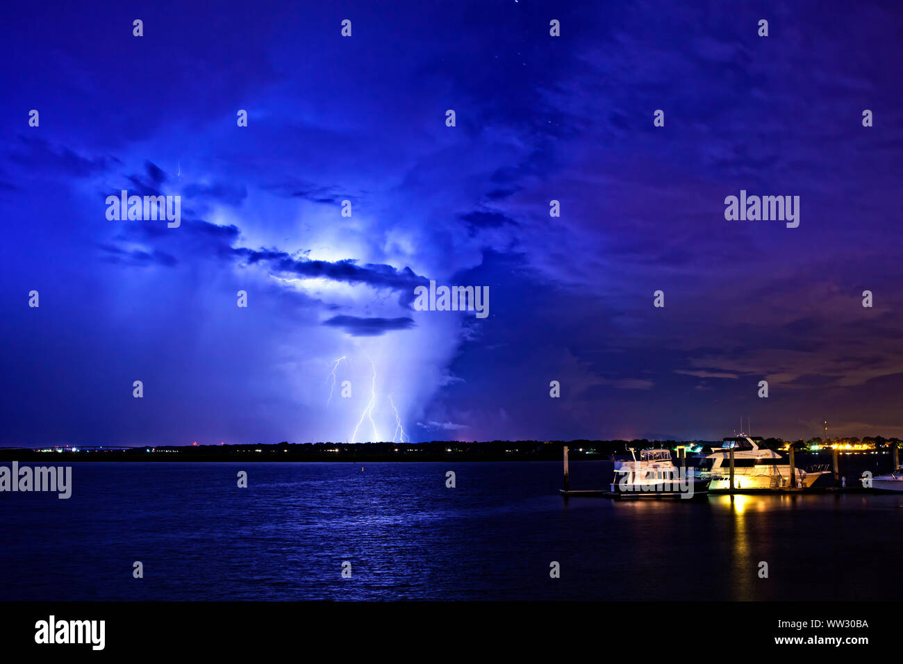 lightning and storm clouds at night over boats Stock Photo Alamy
