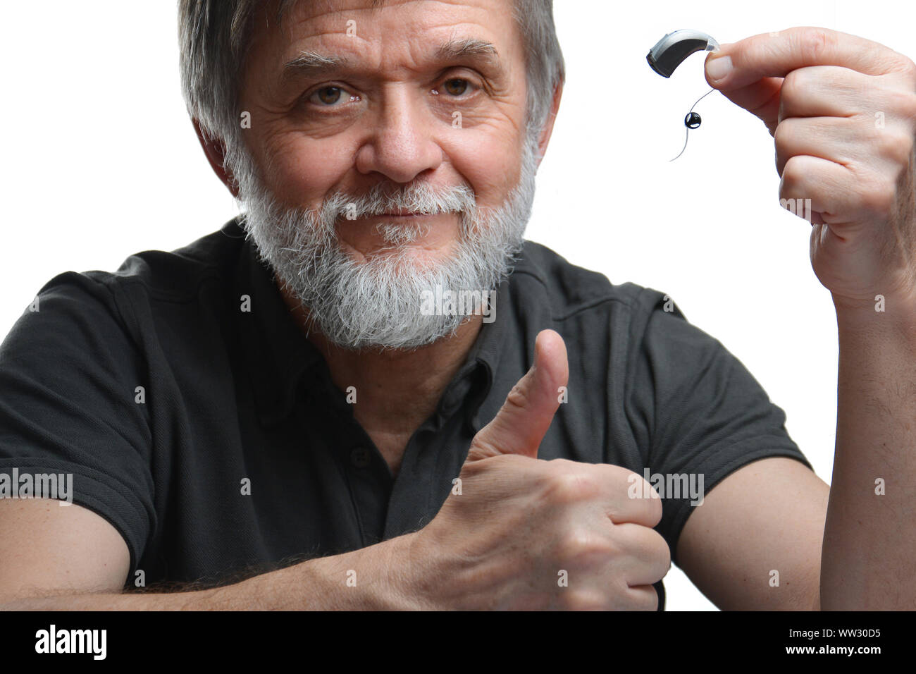 elderly man shows hearing aid Stock Photo