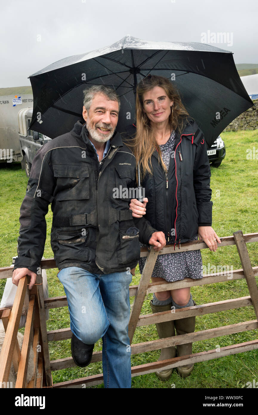 Clive and Amanda Owen shelter from the rain at Muker (agricultural) Show, Swaledale, North Yorkshire. Stock Photo