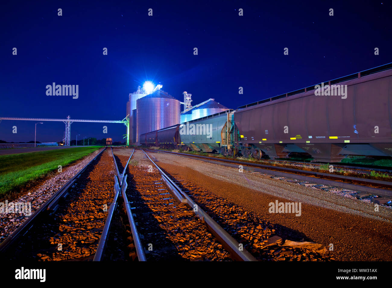 railyard and junction at night with grain elevators Stock Photo