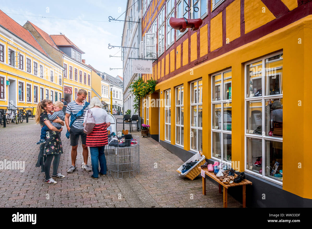 Family standing outside a shoemakers shop, Svendborg, Denmark, 11 July 2019 Stock Photo