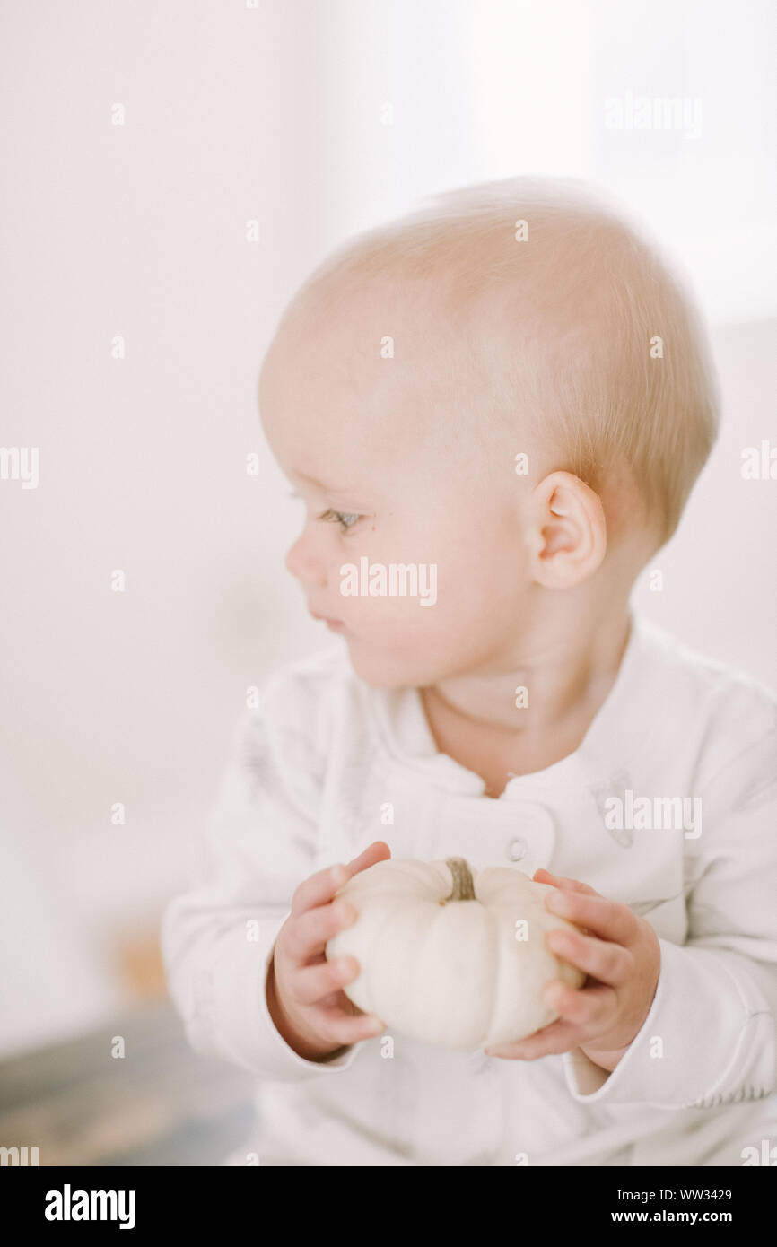 Baby Holding a White Pumpkin Stock Photo