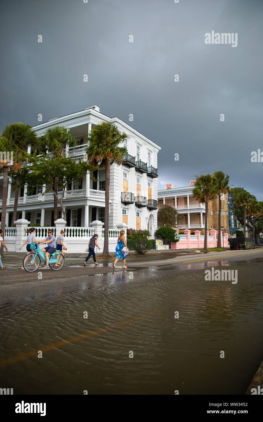 tourists-walk-past-a-historic-homes-at-high-tide-charleston-sc-stock