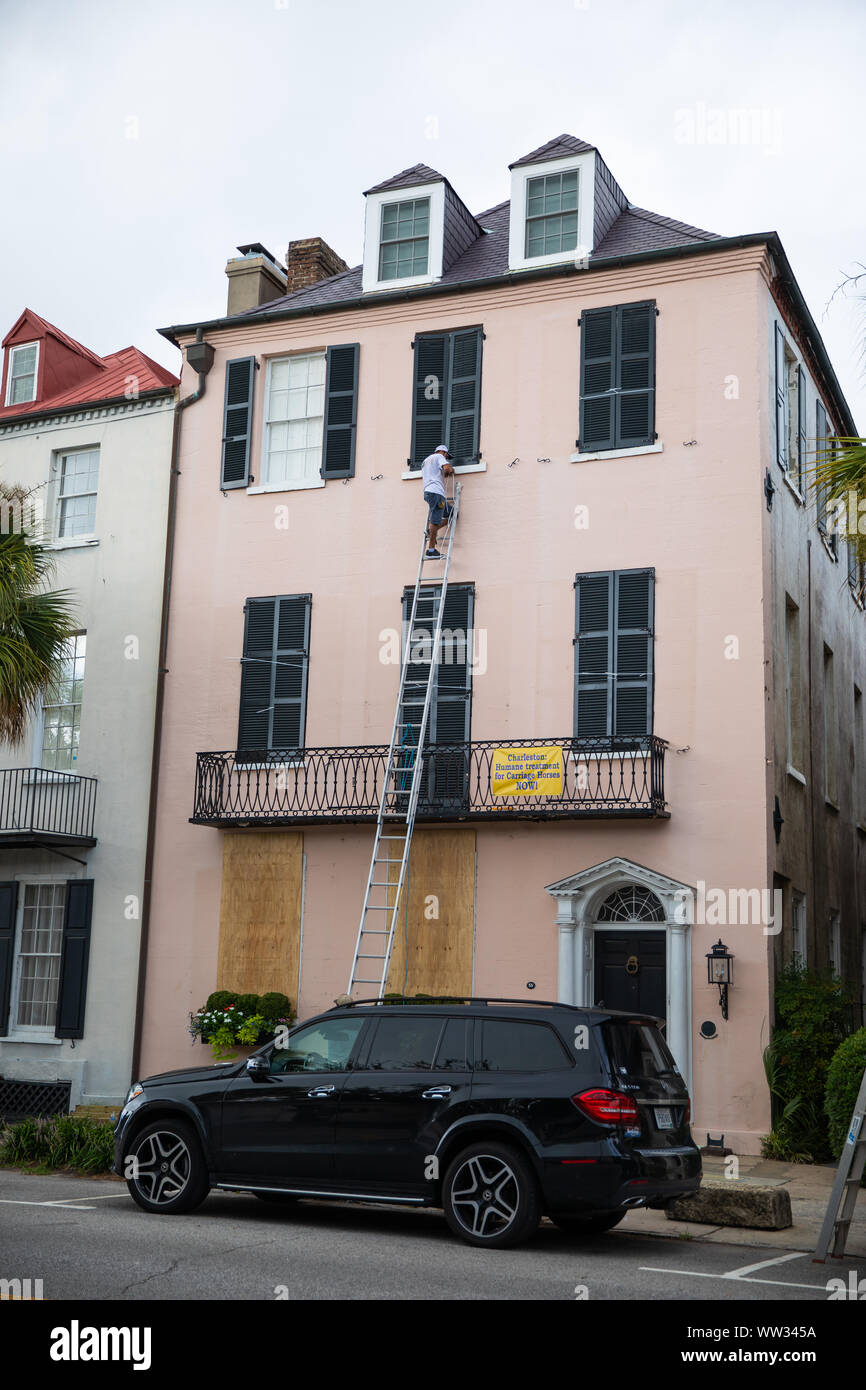 A worker secures shutters ahead of Hurricane Dorian, Charleston, SC. Stock Photo