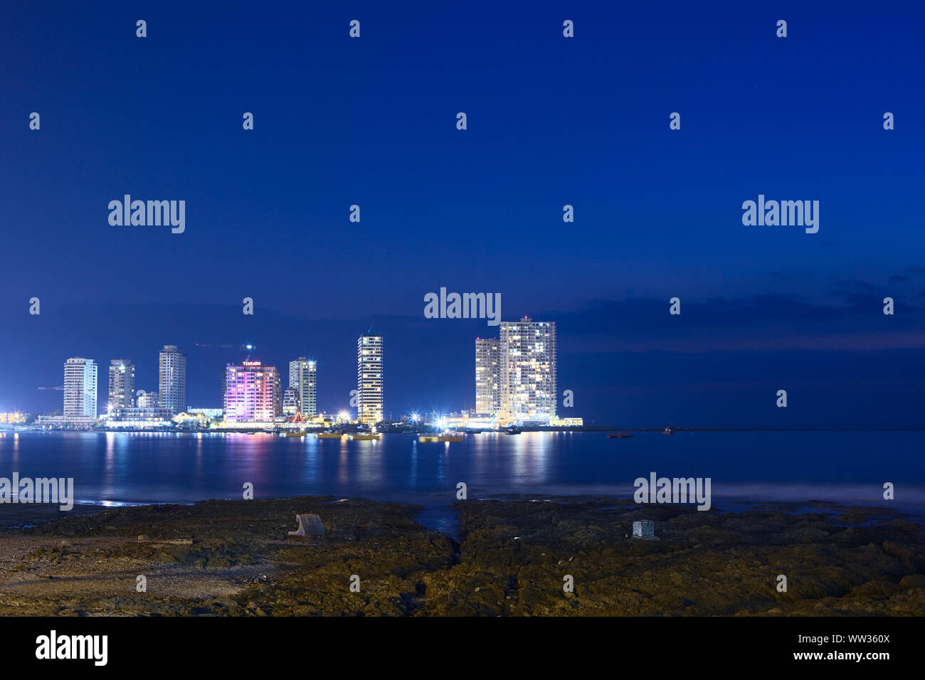 IQUIQUE, CHILE - JANUARY 22, 2015: The peninsula at the end of Cavancha beach with hotels  and modern apartment buildings photographed in the evening Stock Photo