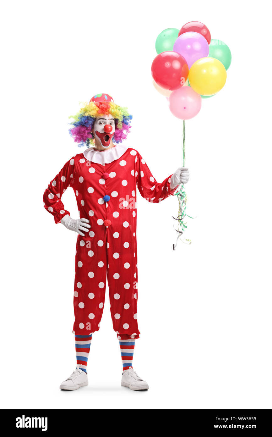 Full length portrait of a cheerful clown holding a bunch of balloons ...