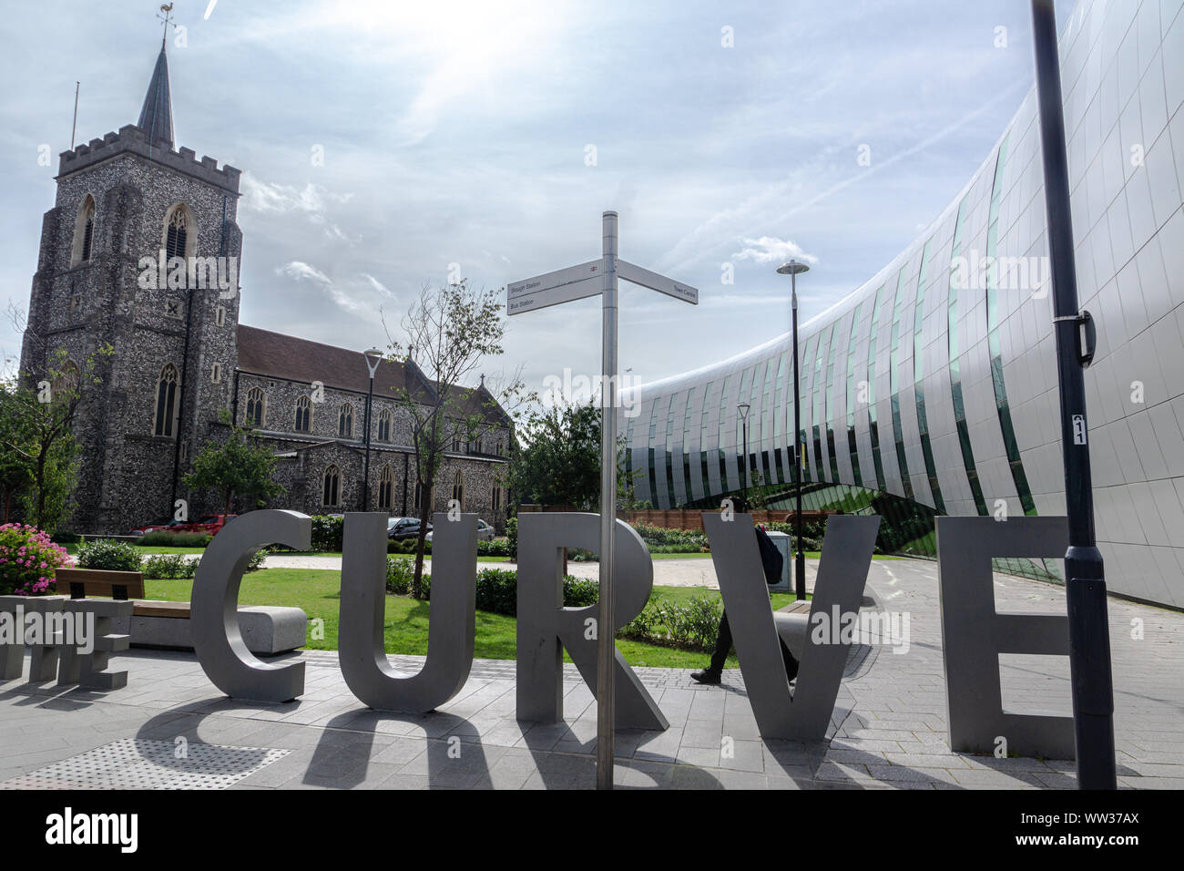 Old and new architecture juxtaposed. 'The Curve' flows towards St Ethelbert's Catholic Church, Slough city centre, Berkshire, England, UK Stock Photo