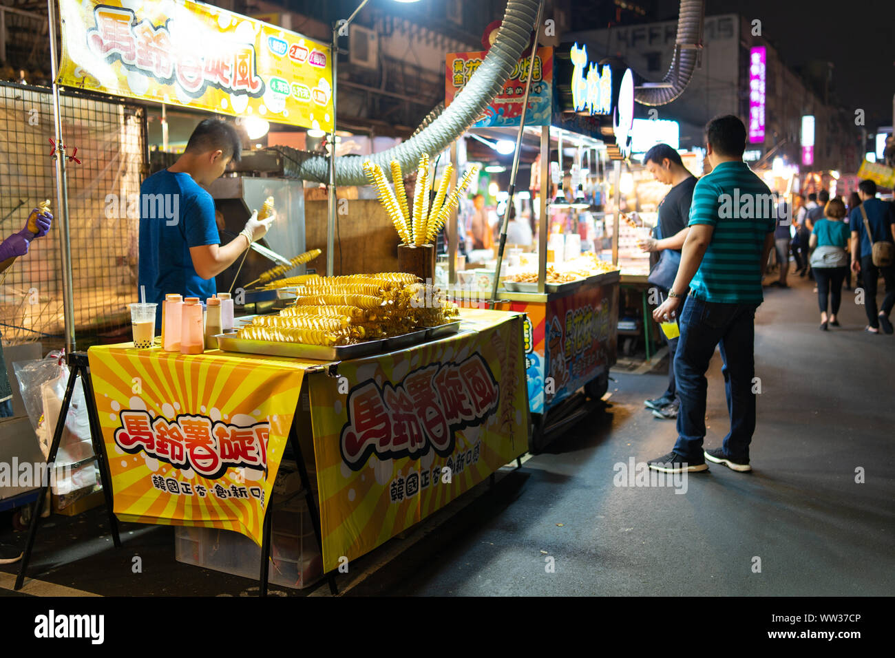 Taipei, Taiwan: Taiwanese street food stall selling Tornado potato, a whole potato cut as a spiral and fired as a big singe potato chip Stock Photo