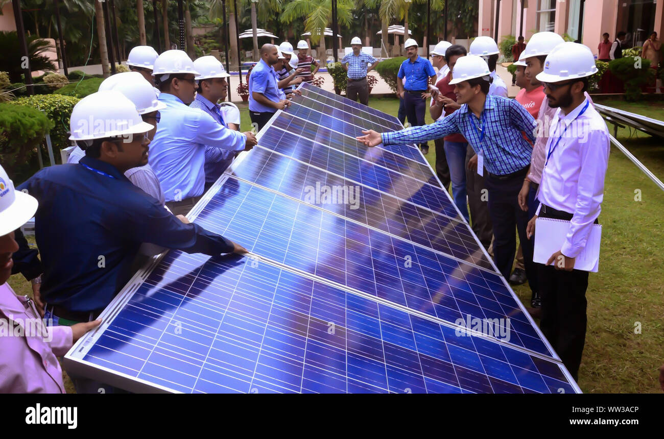 Engineers discussing about the solar photovoltaic cell during a solar power plant traing organised by GERMI in a sunny outdoor. Stock Photo