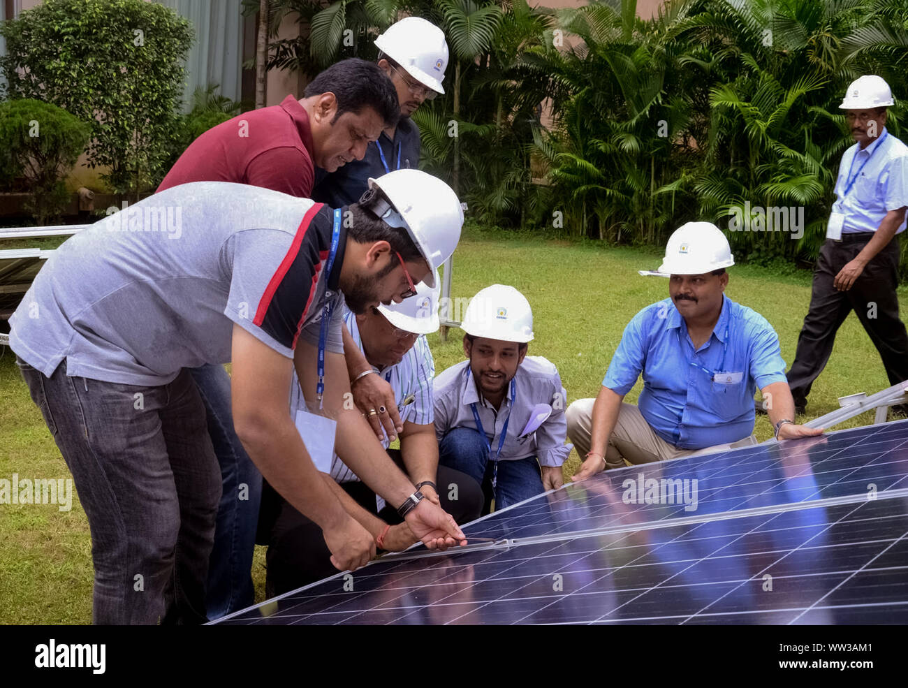 Engineers discussing about the solar photovoltaic cell during a solar power plant traing organised by GERMI in a sunny outdoor. Stock Photo