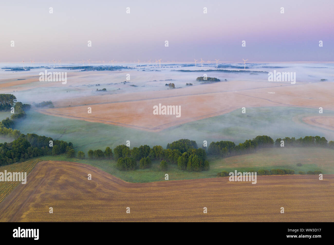 fog on fields, wind turbines in the background. bird's-eye view Stock Photo