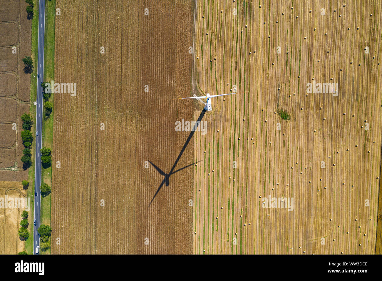 wind turbine on the arable field. road next to farmland Stock Photo