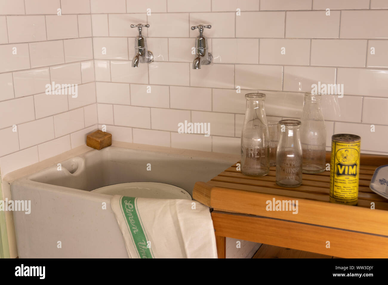 A scene from a 1960's kitchen with tiles, a butler sink, wooden draining board and Vim cleaning powder Stock Photo