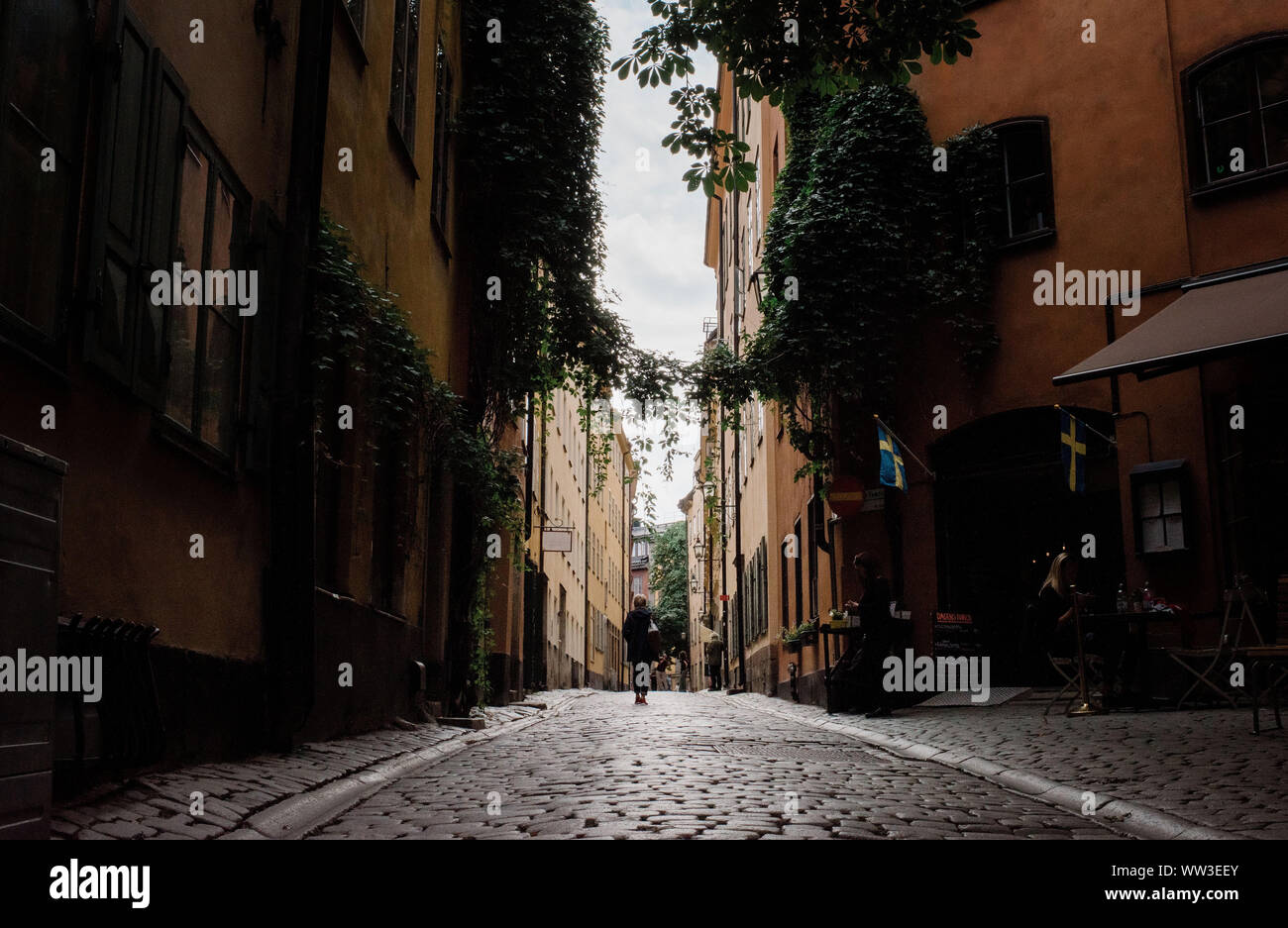 woman walking down traditional European cobbled street as a tourist Stock Photo