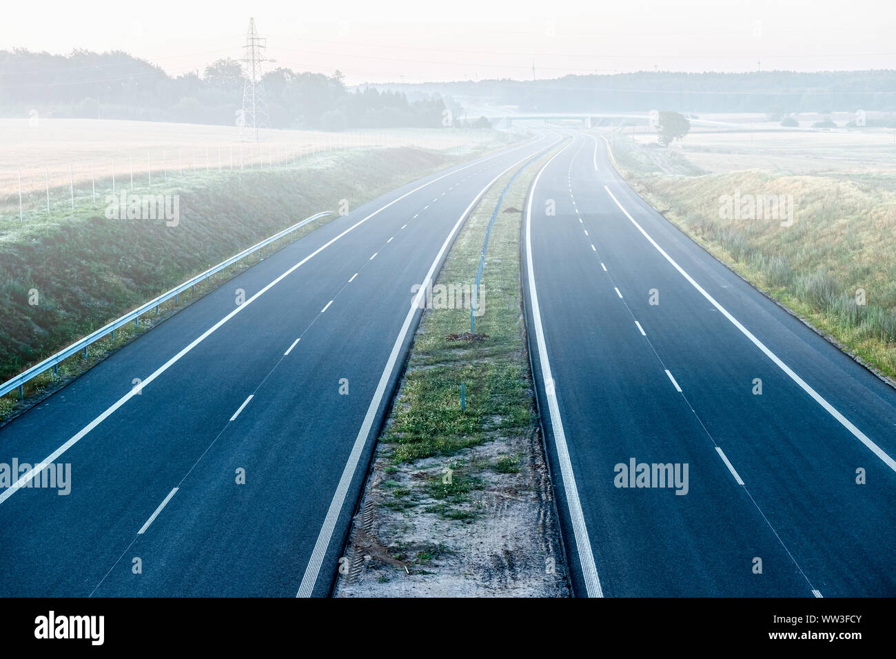 hazy two-lane road stretching out into the horizon Stock Photo