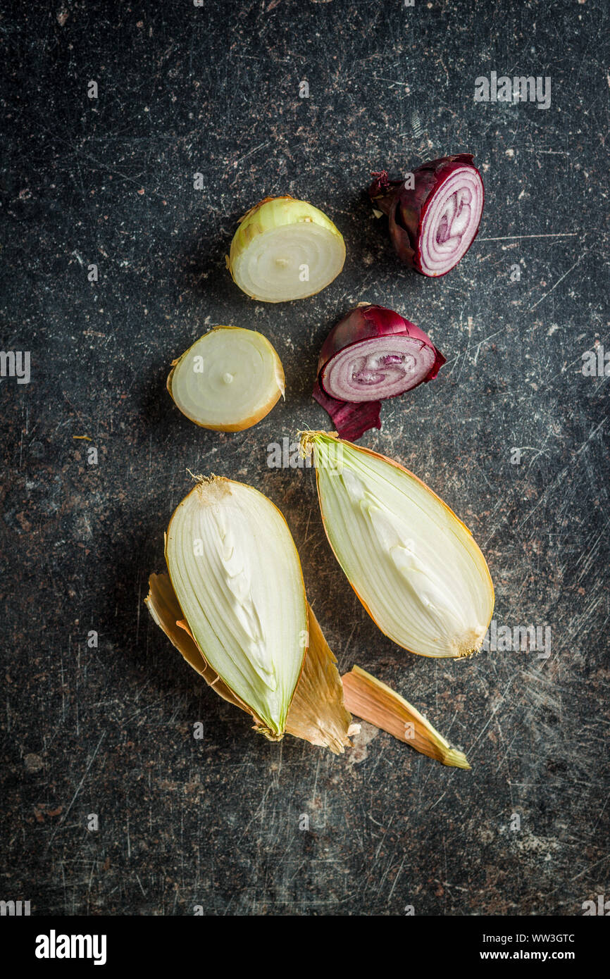 Halved fresh bulbs on old kitchen table. Top view. Stock Photo