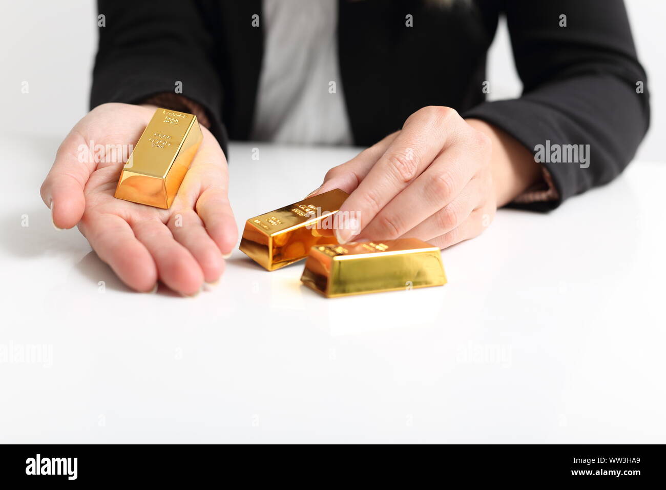 A Business woman presents Gold bullion bar Stock Photo
