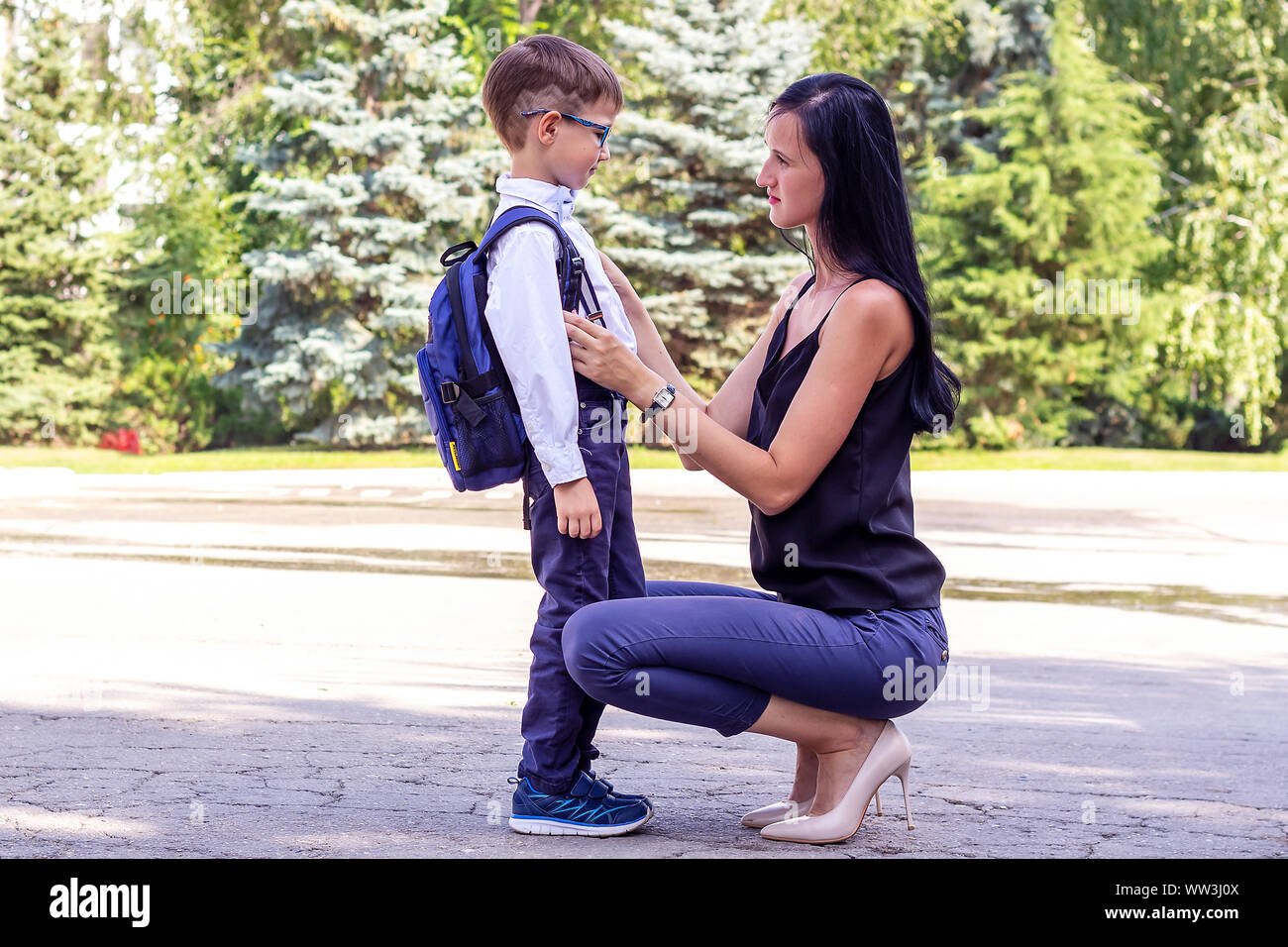 Young brunette mom escorts her first-grader's son to school Stock Photo