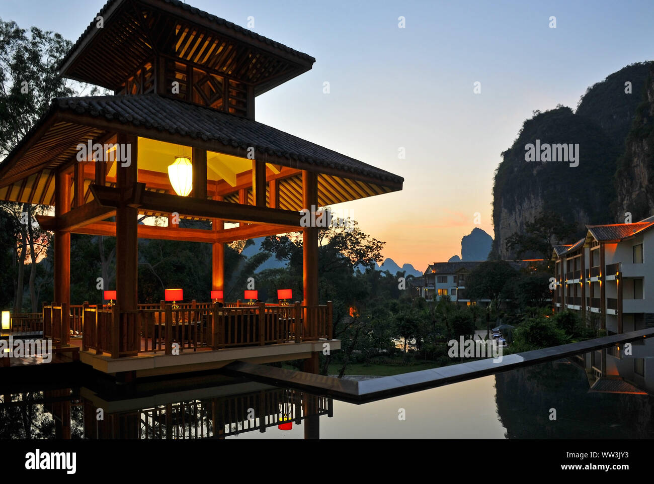 The karst geologic rock formations and chinese architecture in Yangshuo at sunset, Guangxi province, China. Stock Photo