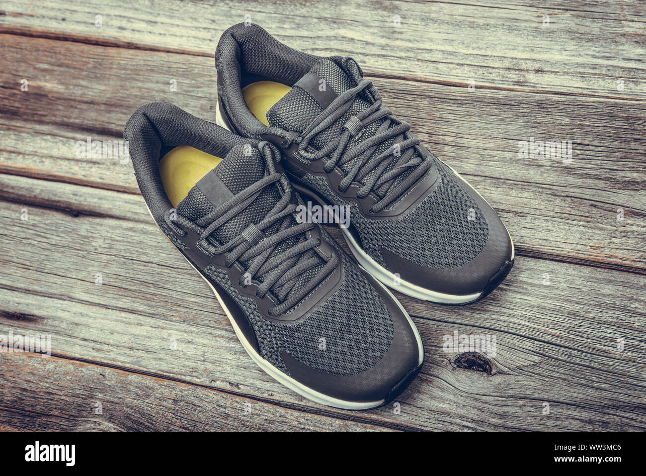 Black sneakers on a wooden background. Stock Photo